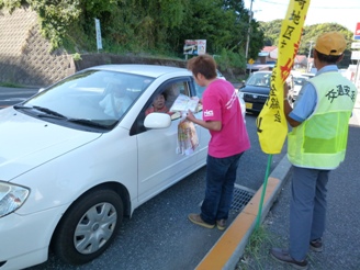 ドライバーに安全運転のチラシを手渡す濱田さん