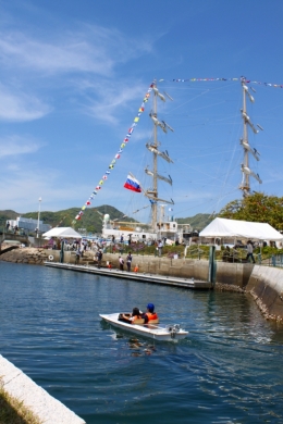 帆船と長崎港を背景に進むソーラーボート